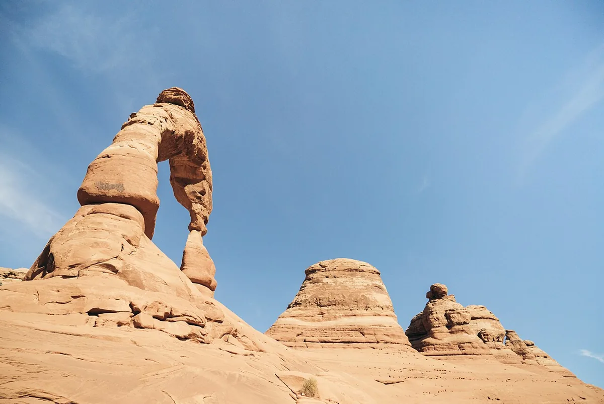Delicate Arch rising above sandstone beneath a clear blue sky