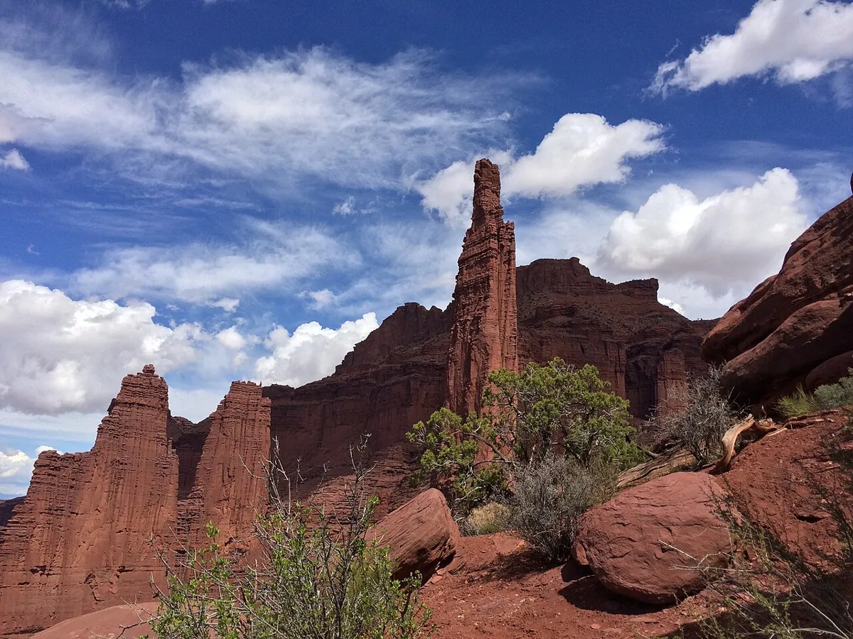 Red sandstone spires of Fisher Towers under a partly cloudy sky