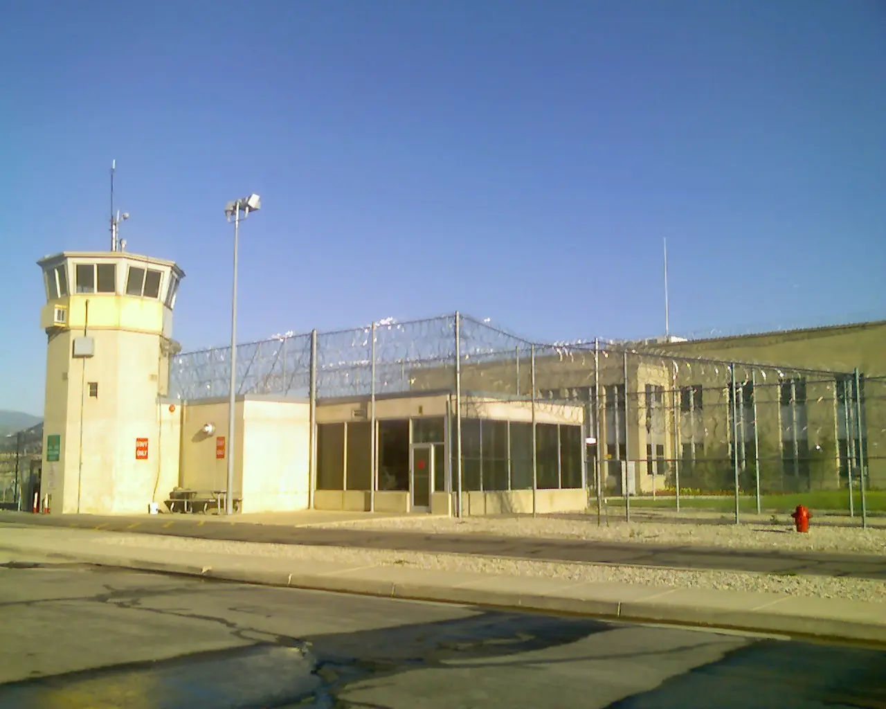 Guard tower and entrance building at the Utah State Prison in Draper, behind razor-wire fencing