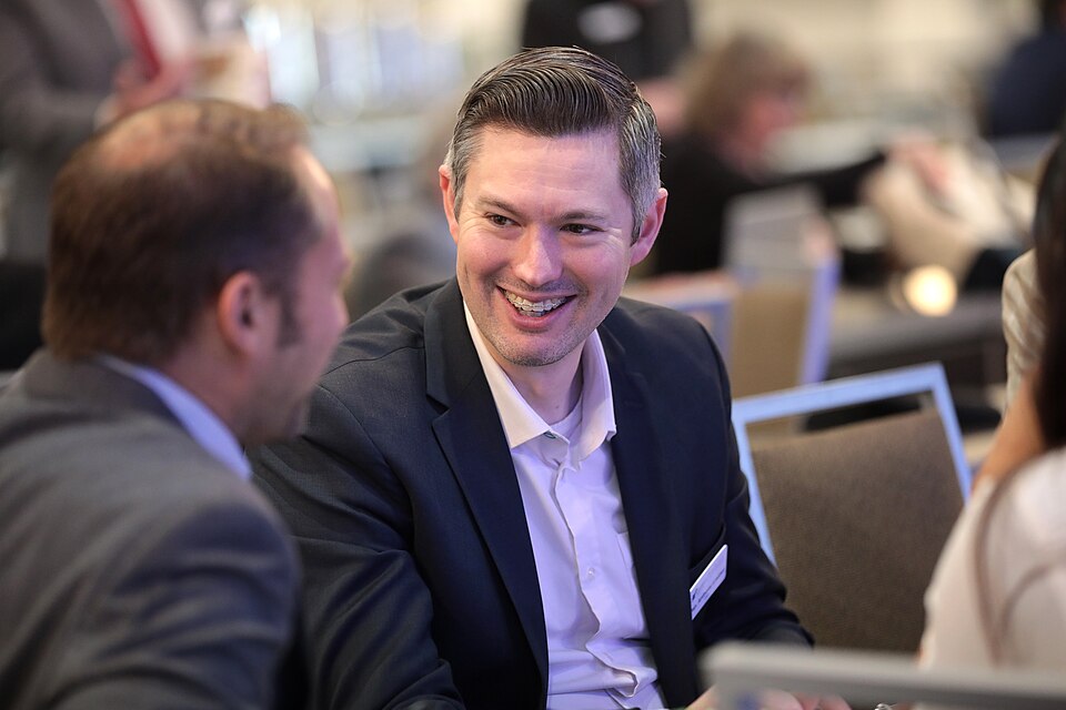 Anthony Loubet smiling while seated at a roundtable.