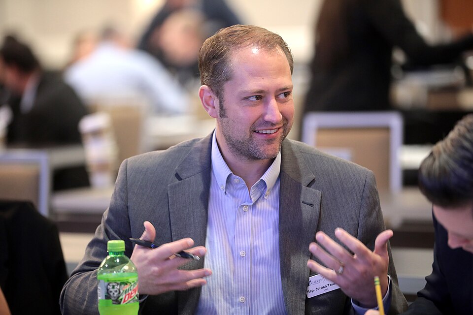 Jordan Teuscher gesturing during a roundtable discussion.