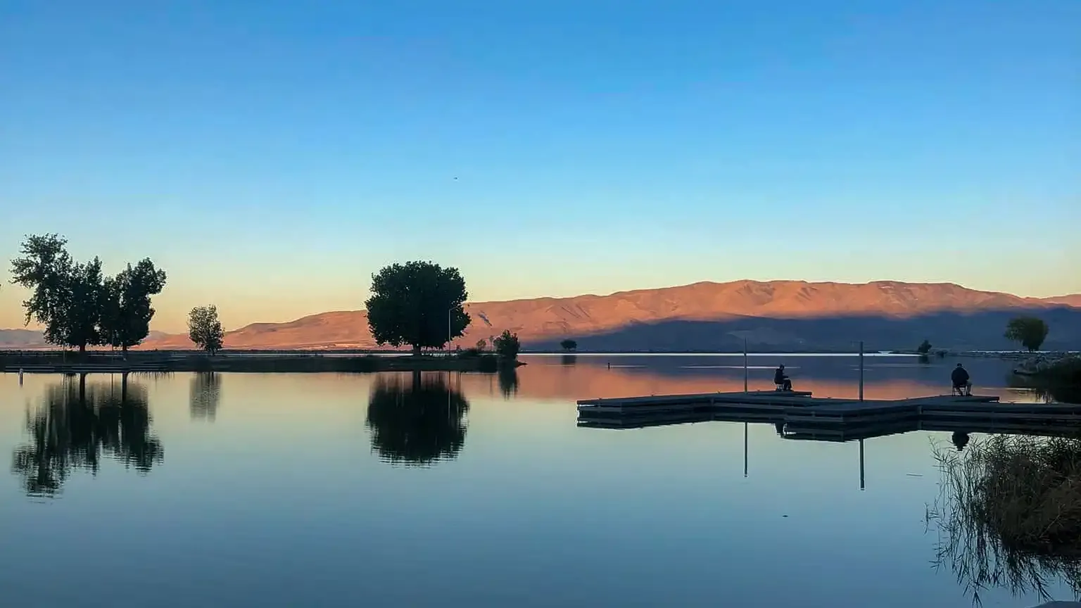 Calm water and marina docks at Utah Lake State Park with distant mountains