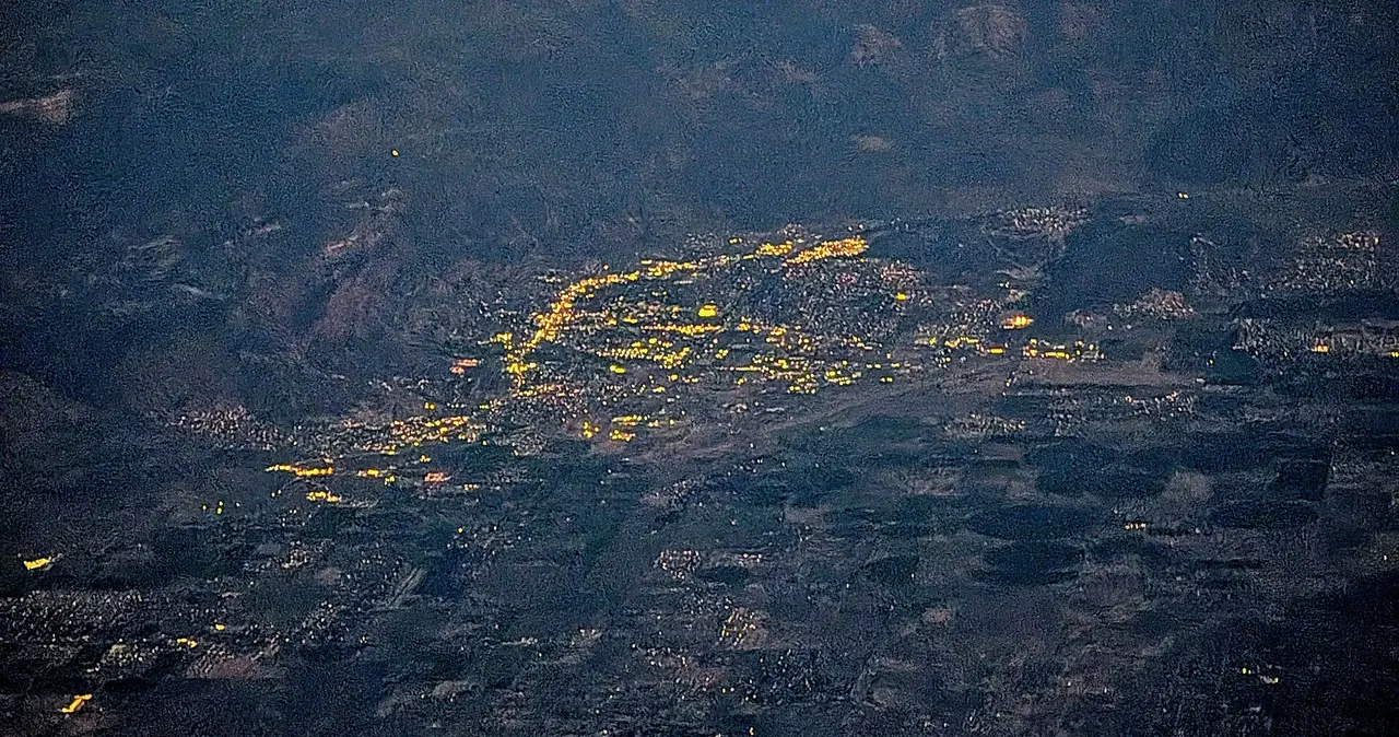 Aerial view of Cedar City at dusk, with the city lights below the mountains