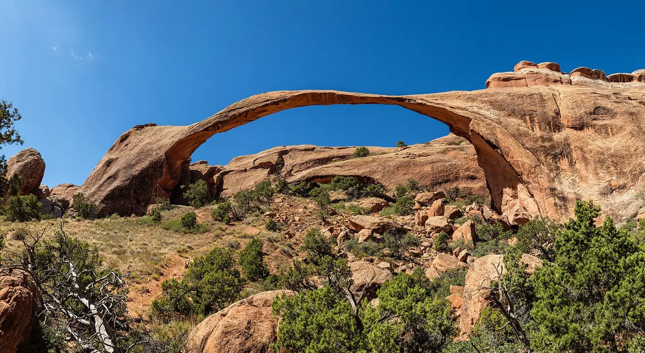 The long, thin ribbon of Landscape Arch spanning a sandstone fin in Arches National Park's Devils Garden