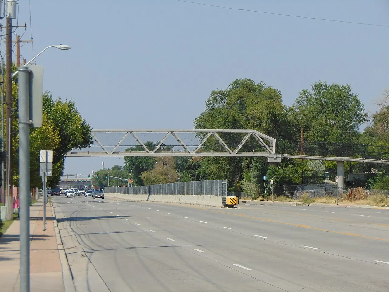 Northbound view along Redwood Road beneath a pedestrian bridge in West Valley City